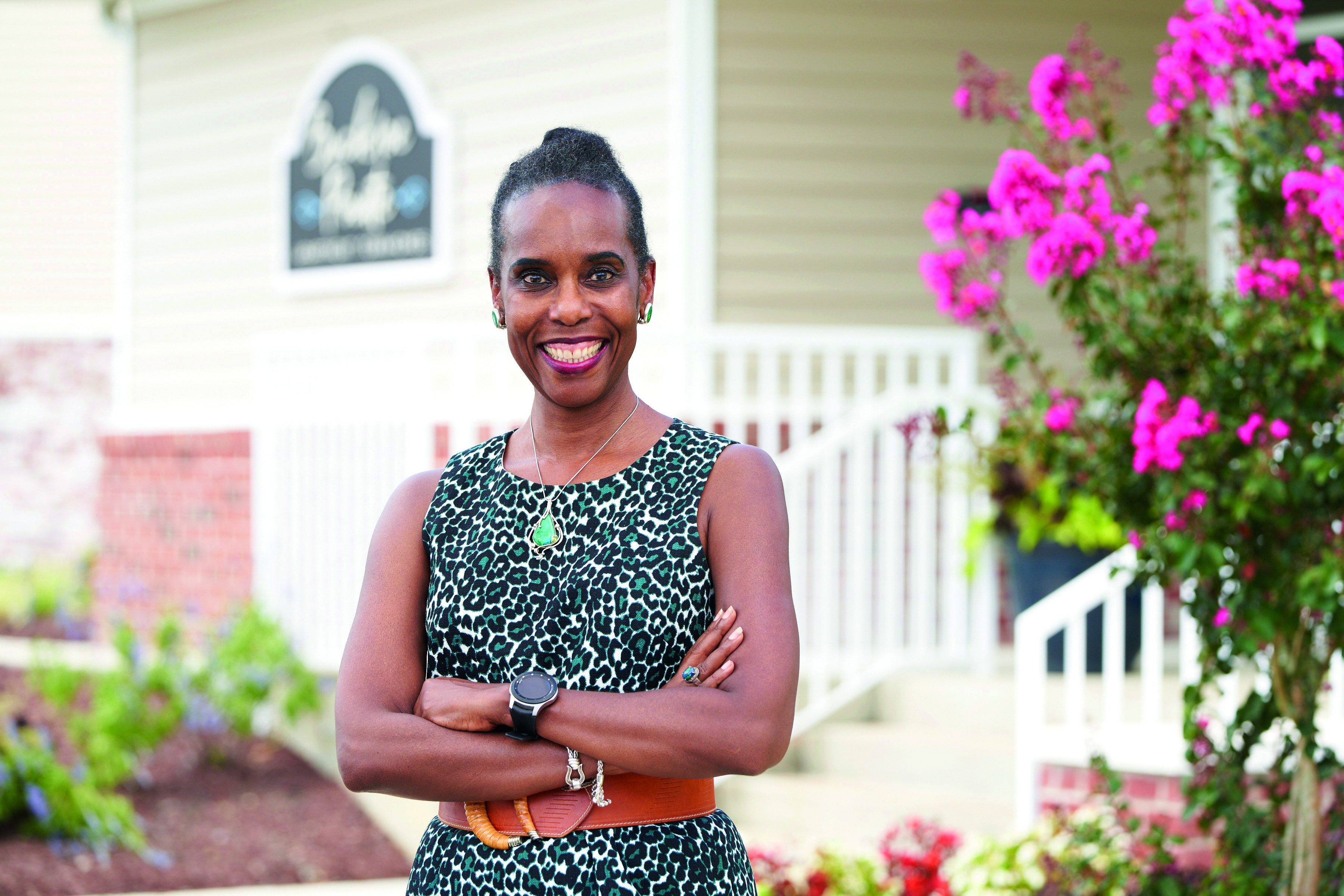  Faith Linton, Real Estate Devloper in front of flowers and building